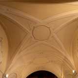 Il soffitto voltato invece mostra geometriche cornici modanate a stucco bianco